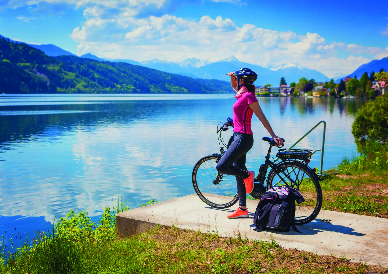 woman with e-bike enjoying view over lake