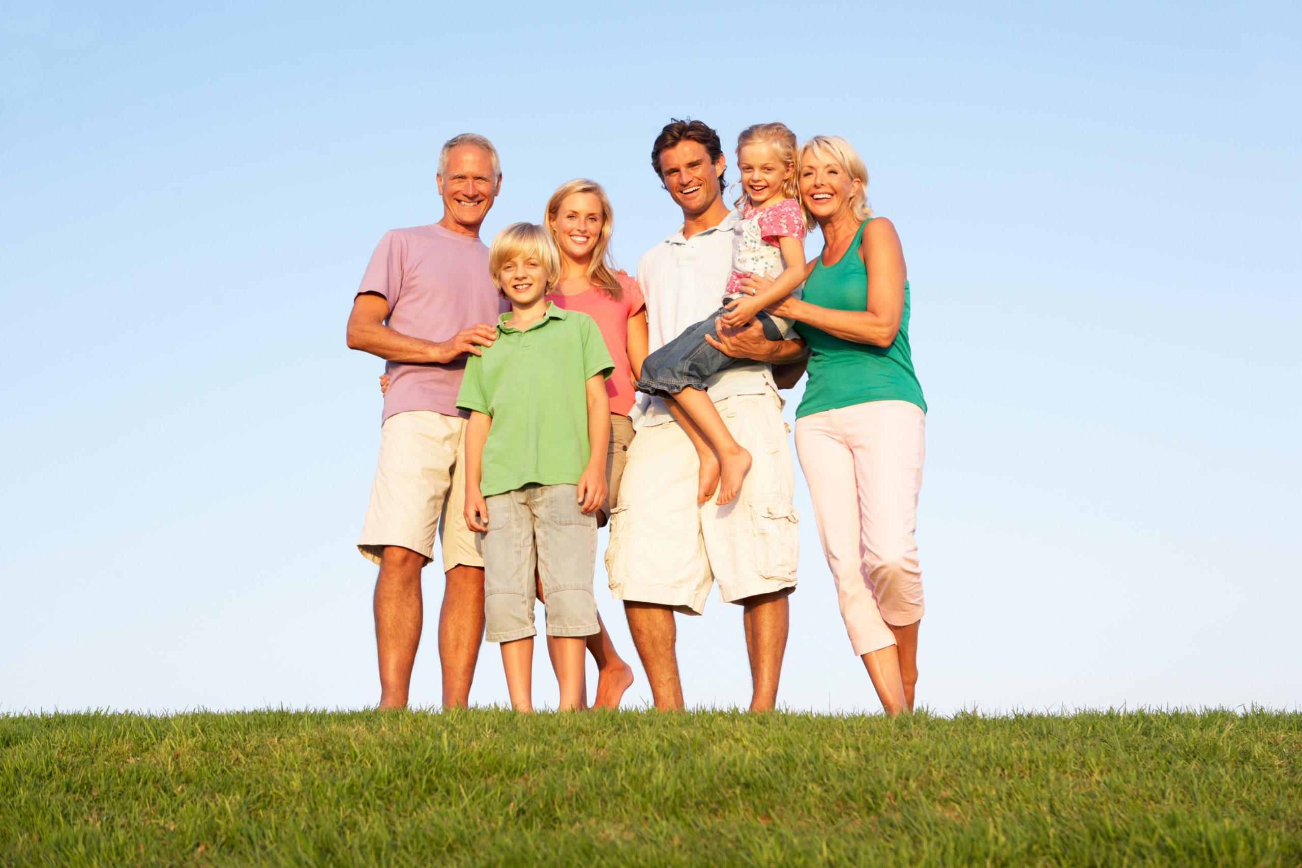 A family, with parents, children and grandparents, posing in a field